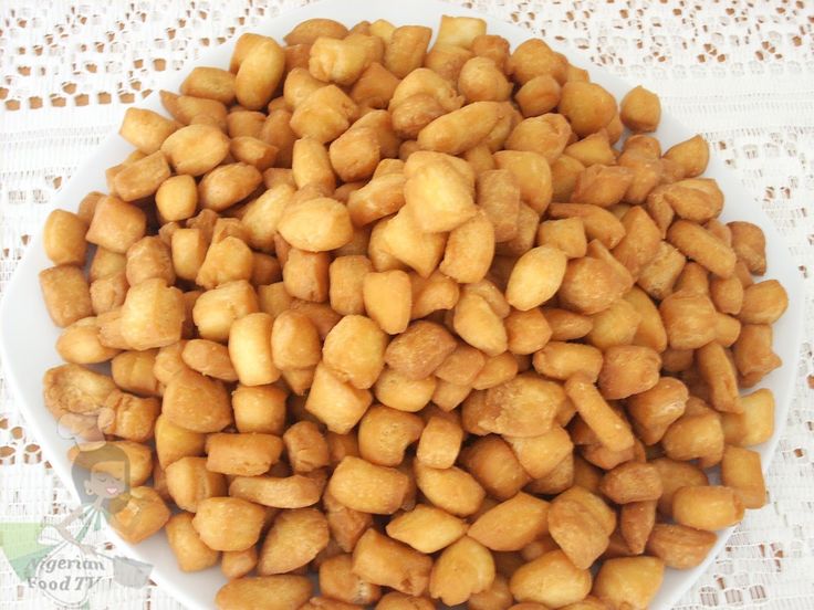 a white bowl filled with chickpeas on top of a lace tablecloth covered table