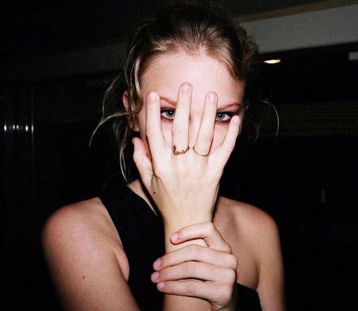 a young woman covers her face with her hands