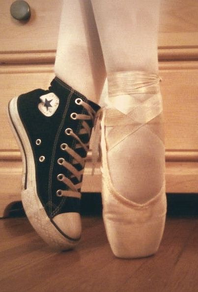 a person wearing black and white shoes standing next to a dresser