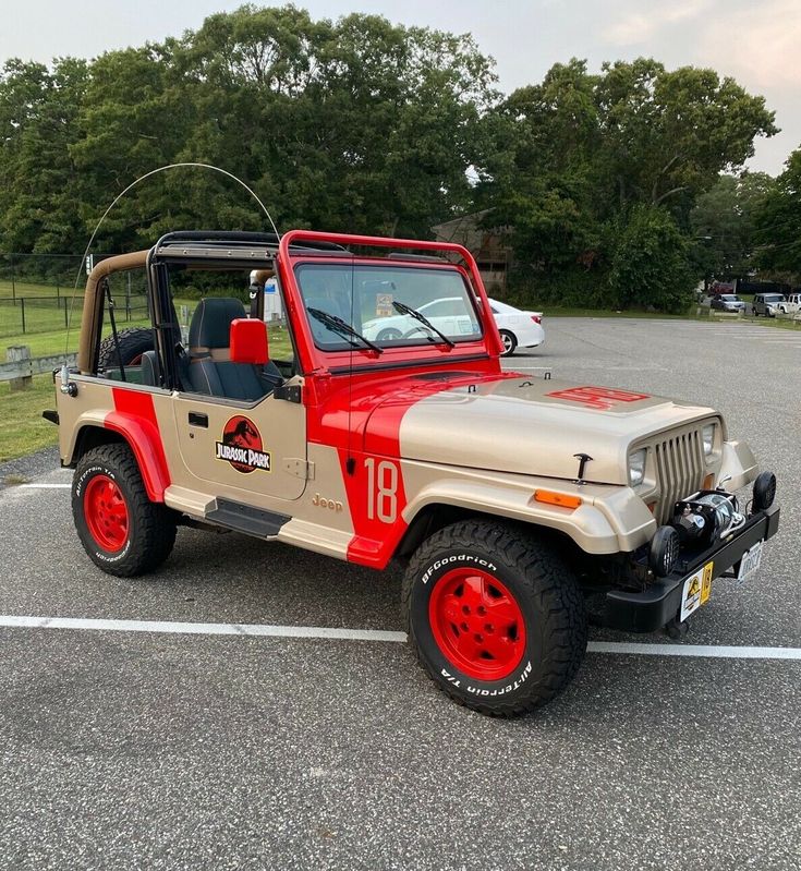 a red and tan jeep parked in a parking lot