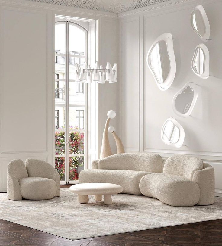 a living room with white furniture and mirrors on the wall