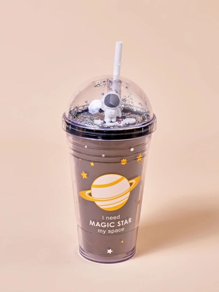 a plastic cup with a straw in the shape of a saturn and stars on it