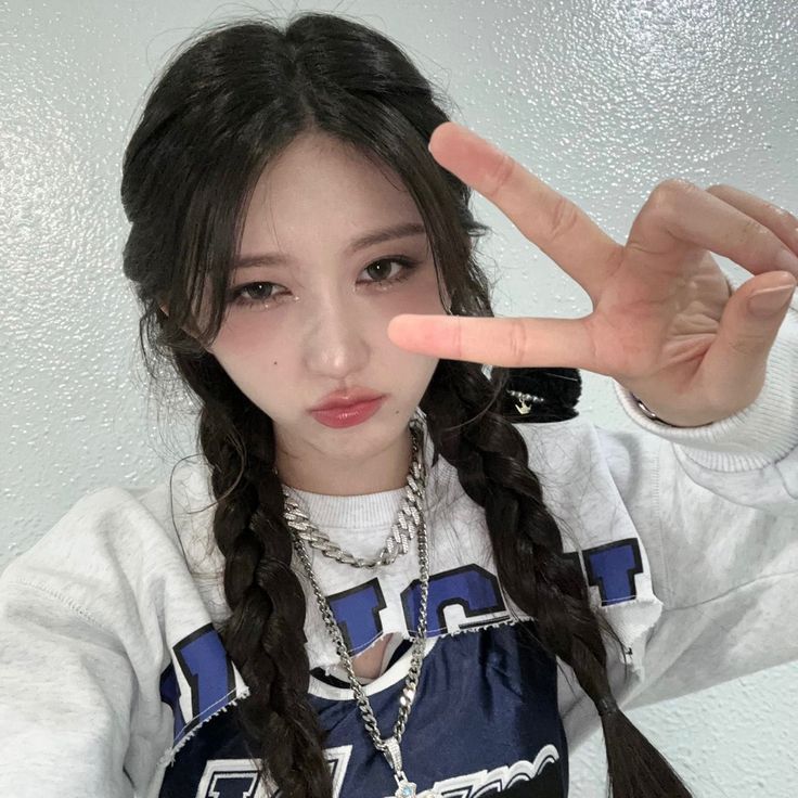 a girl with long hair making the v sign