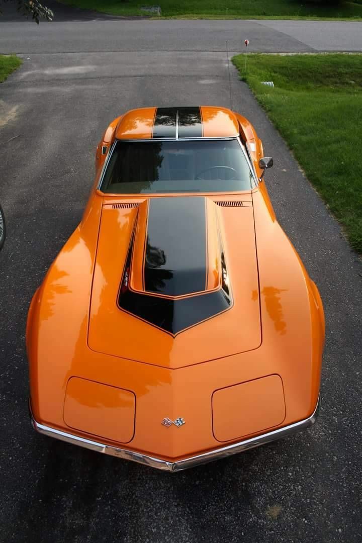 an orange sports car parked in a driveway