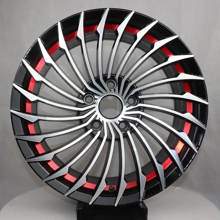 a black and red wheel on a white surface with some light coming from it's center