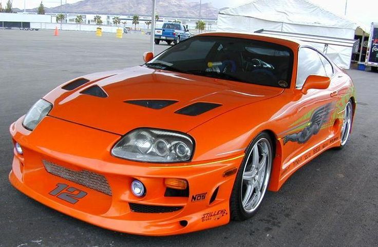 an orange sports car parked in a parking lot