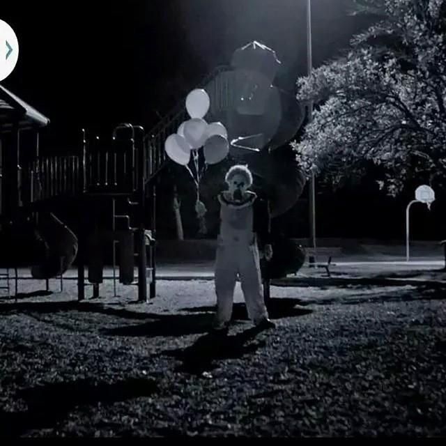 a person holding some balloons in the dark