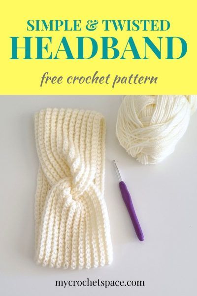 a white knitted headband next to a ball of yarn and a crochet hook