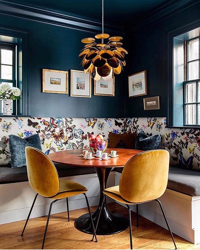 a dining room with blue walls and yellow chairs