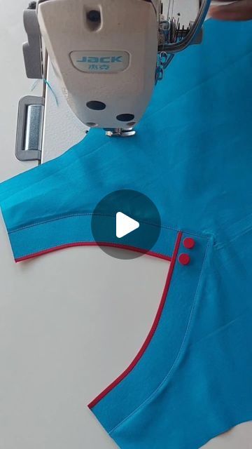 someone is using a sewing machine to sew the top of a blue t - shirt