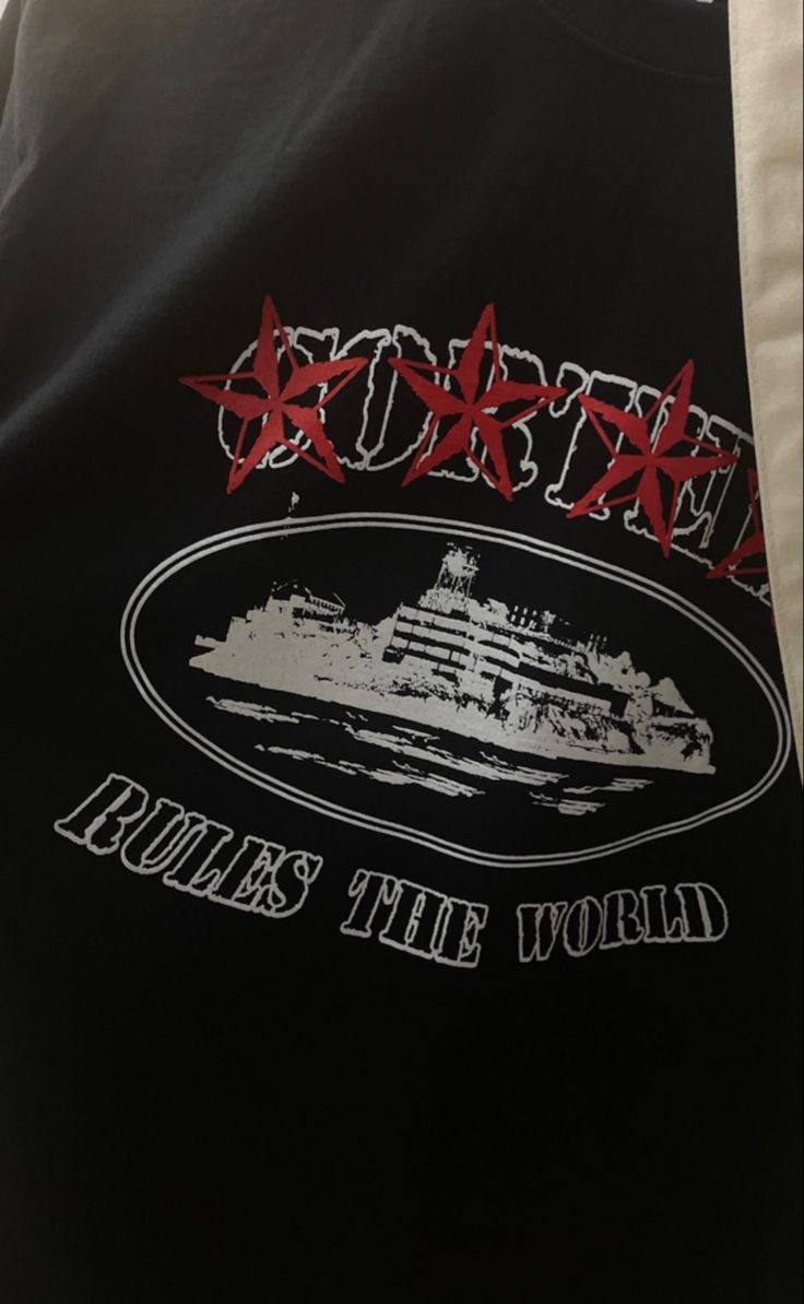 the back of a black jacket with red writing on it and a ship in the background