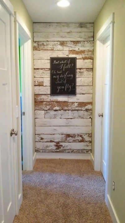 an empty hallway with a chalkboard sign on the wall and carpeted flooring