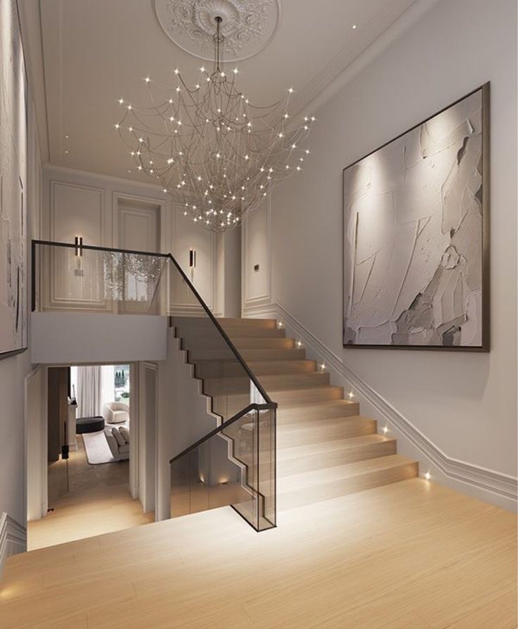 a staircase leading up to a living room and dining room area with chandelier
