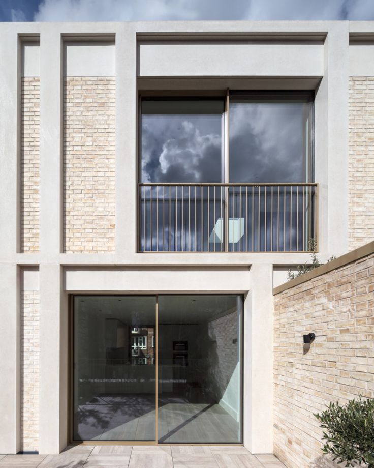 the entrance to an apartment building with glass doors and brick walls on either side of it