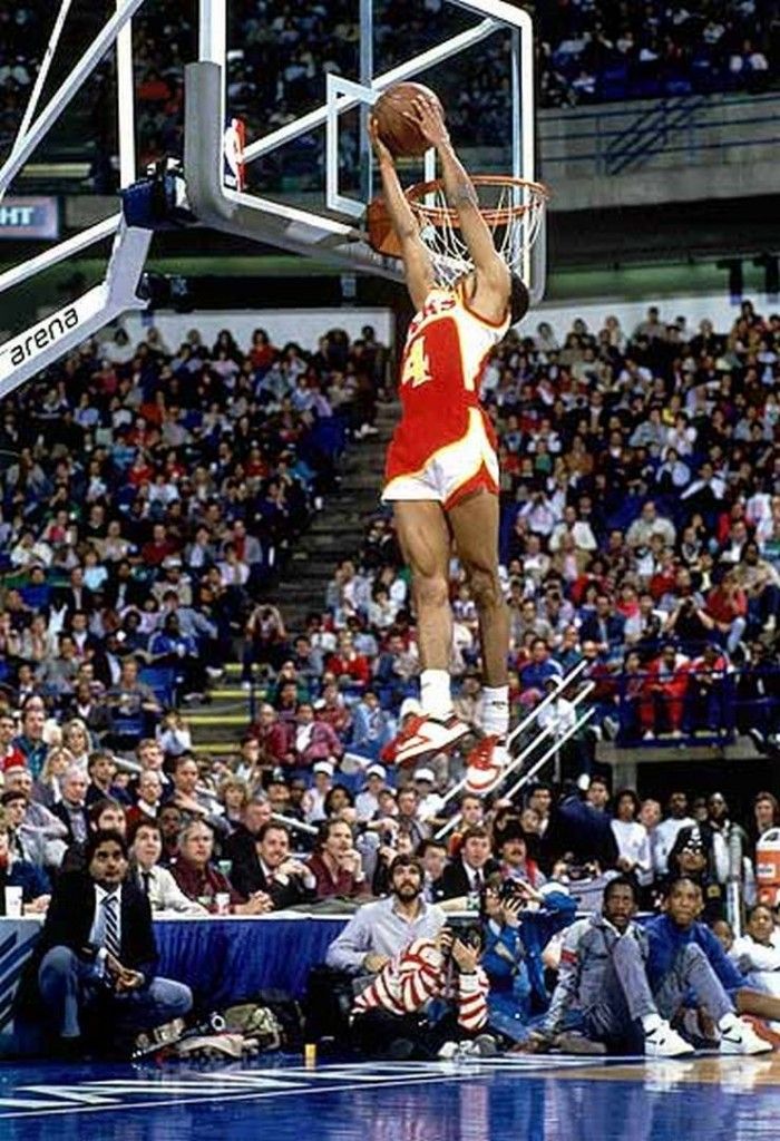 a basketball player dunking the ball in front of an audience