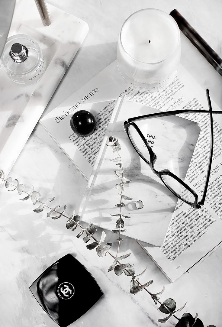 an assortment of eyeglasses and other items on a marble table with white background