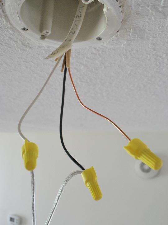 two wires are connected to the ceiling light fixture in this room with white walls and ceilings