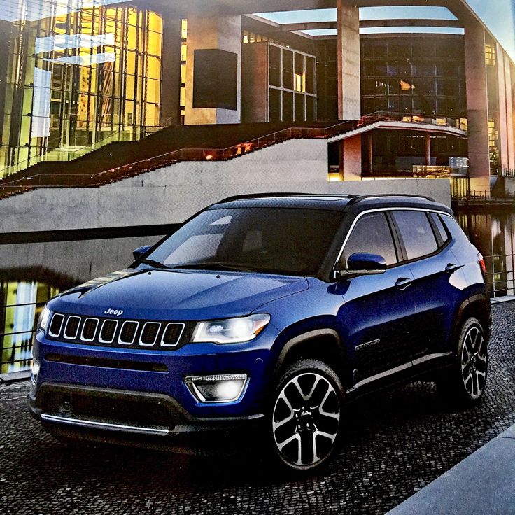 a blue jeep parked in front of a building