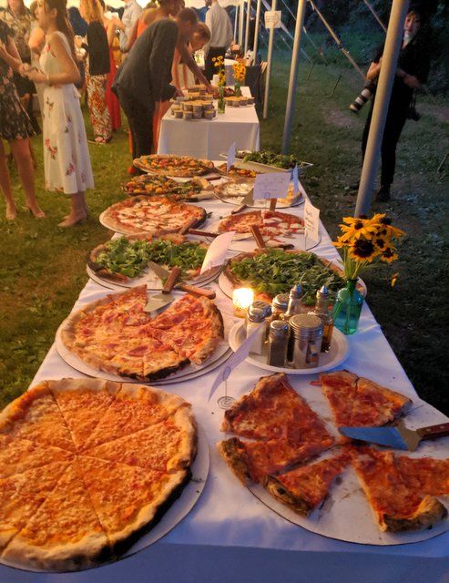 many pizzas are on the table ready to be served at an outdoor party or social gathering