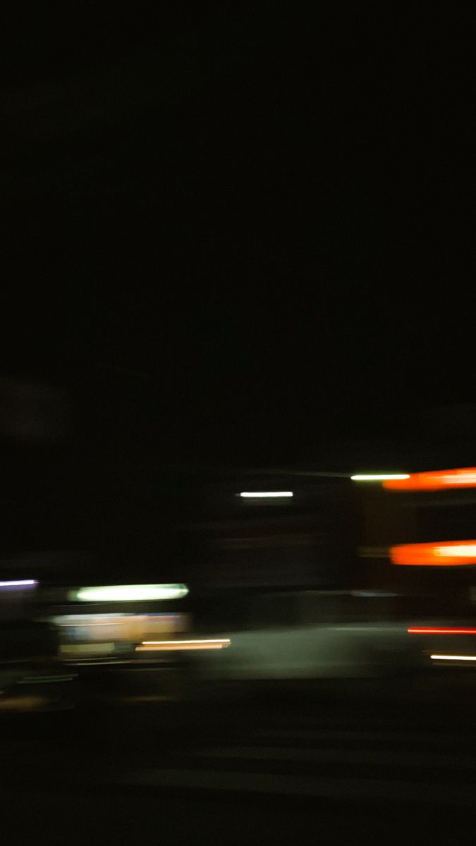 blurry photograph of trucks in motion at night