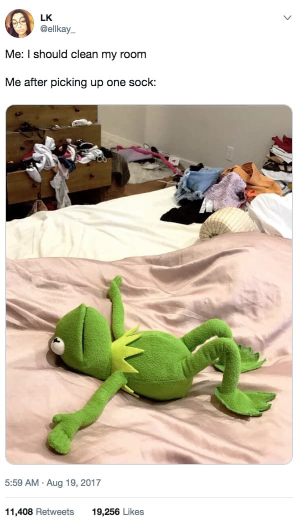 a green stuffed animal laying on top of a bed