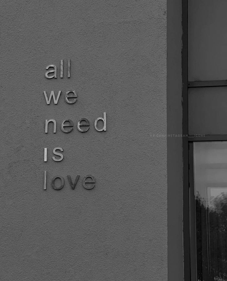 all we need is love written on the side of a building in black and white