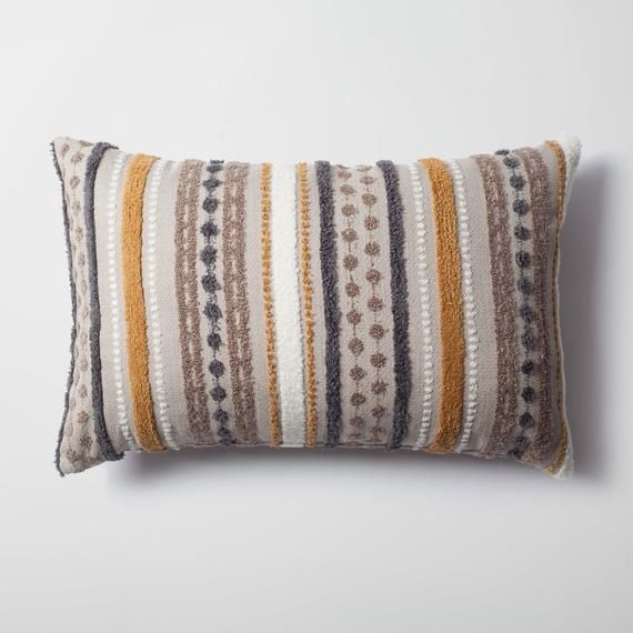 a striped pillow sitting on top of a white wall