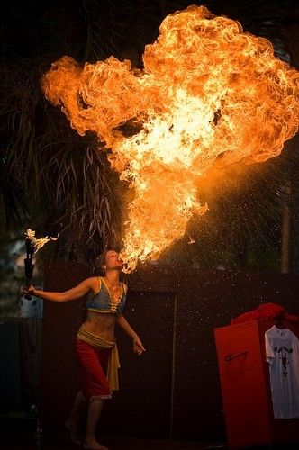 a woman is dancing with fire in her hand