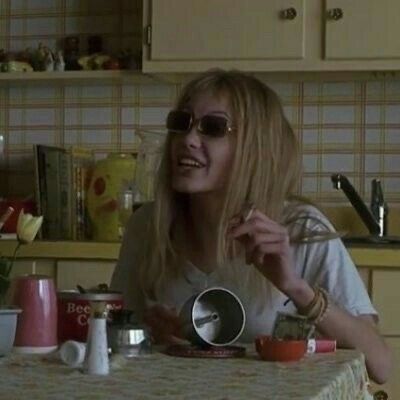 a woman sitting at a table with cups and saucers