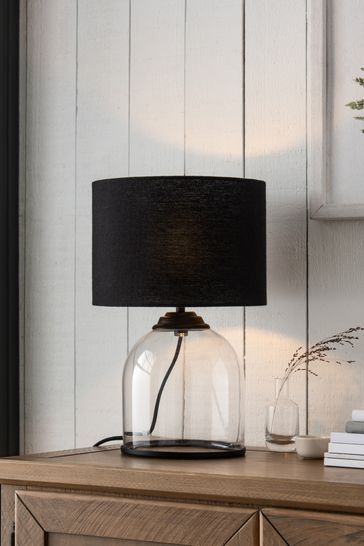 a lamp that is sitting on top of a wooden table next to a book shelf