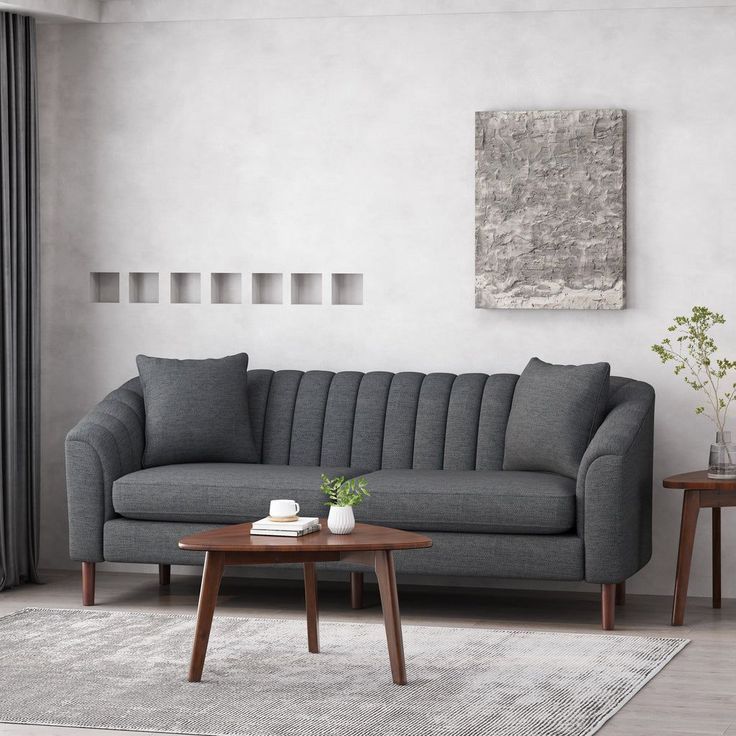 a living room with a gray couch and coffee table in front of the window,