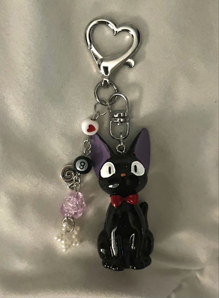 a black cat keychain with a heart on it's head and eyes