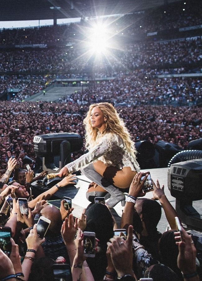 the singer is surrounded by fans as she performs on stage at a concert in front of an audience