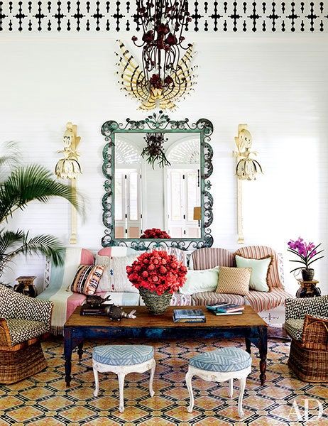 a living room filled with furniture and a large mirror on the wall over a coffee table