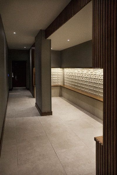 an empty room with several mailboxes on the wall and some lights in the ceiling