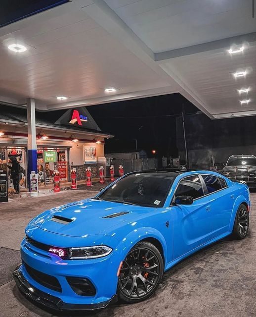 a blue car parked in front of a gas station