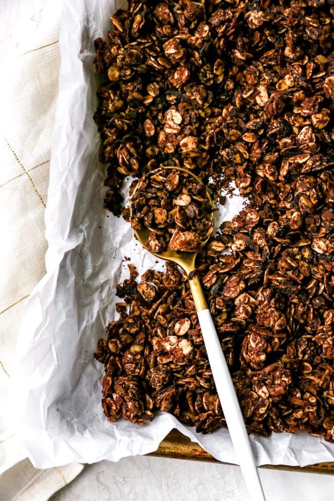 granola on parchment paper with a spoon in it