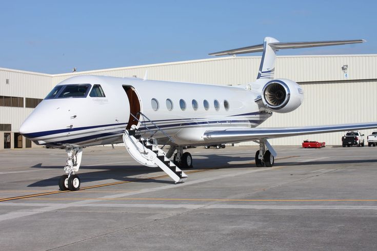 an airplane parked in front of a building with stairs leading up to it's door