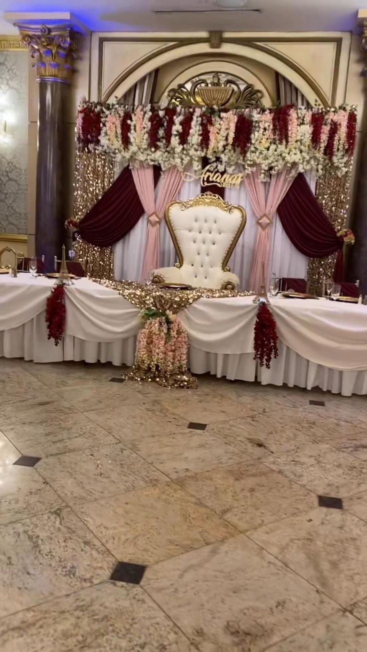 a banquet hall with tables and chairs decorated in red, white and gold colors for an event