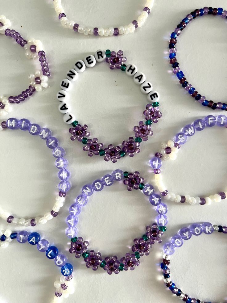 several bracelets with words written on them and beads around the edges that spell out names