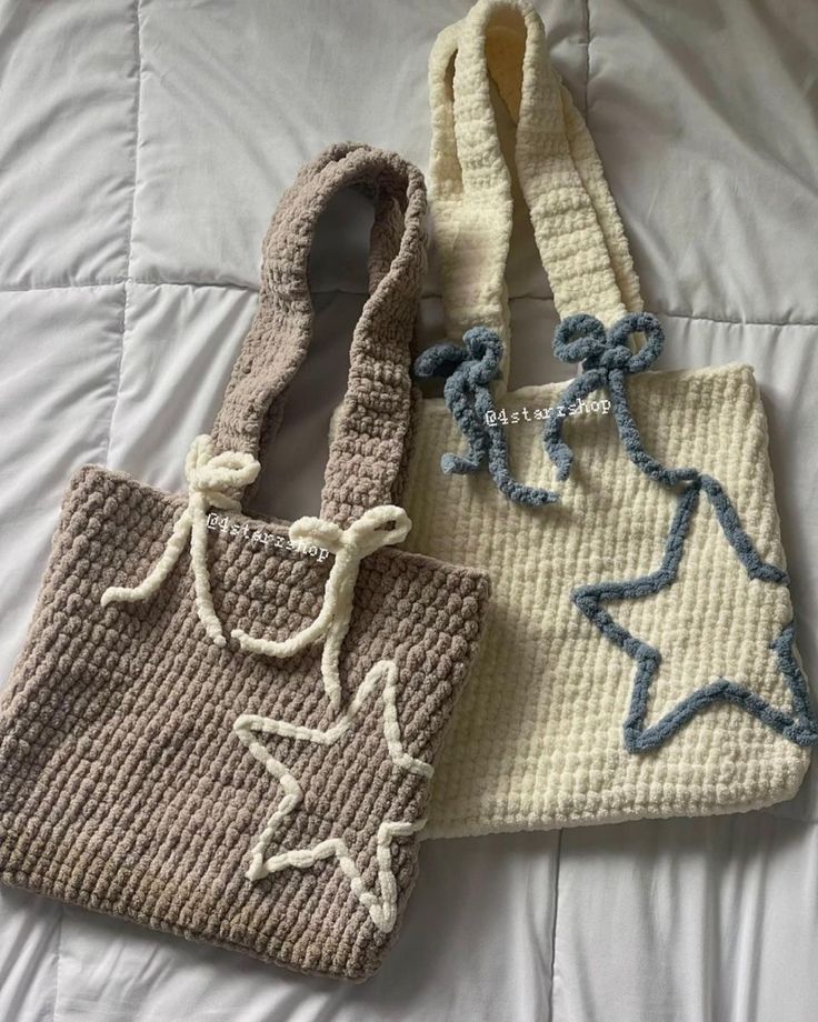 two crocheted purses sitting on top of a bed next to each other