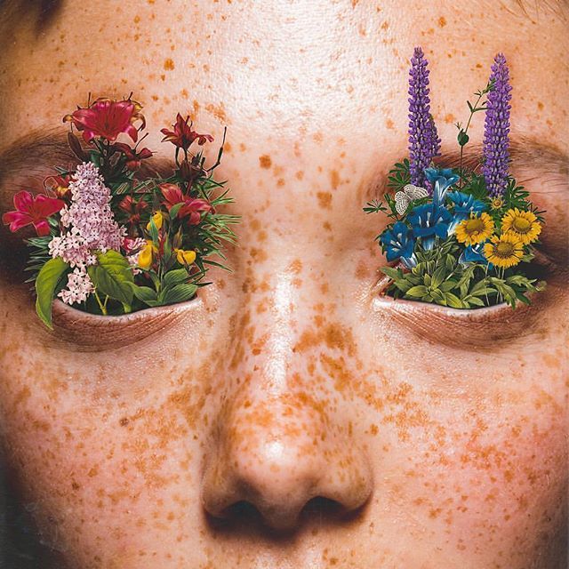 a woman with freckles on her face has flowers in their eyes