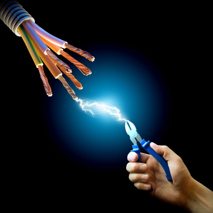 a hand holding a pair of scissors with wires coming out of it