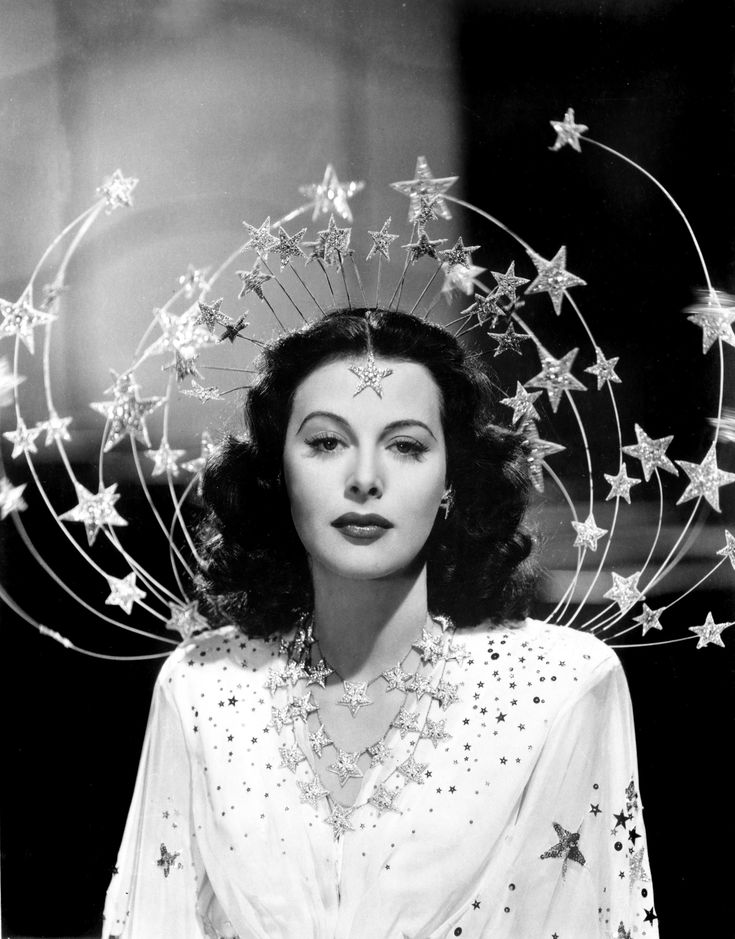 a black and white photo of a woman with stars on her head