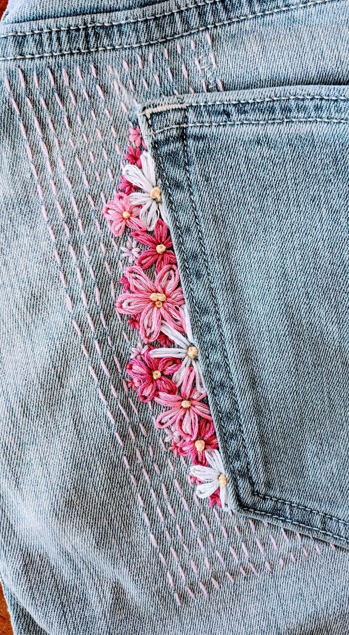 a pair of jeans with pink flowers in the pocket