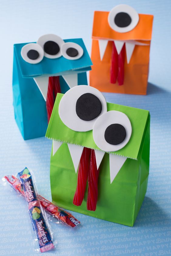 two paper bags with googly eyes and one has toothbrushes in its mouth