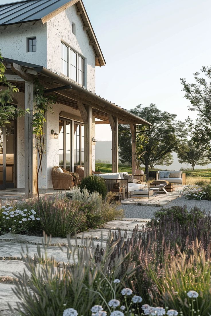 a large house with lots of plants and flowers around it's front porch area