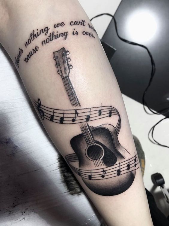 a tattoo with musical notes and an acoustic guitar on the left arm that says, nothing we can't do was nothing in one