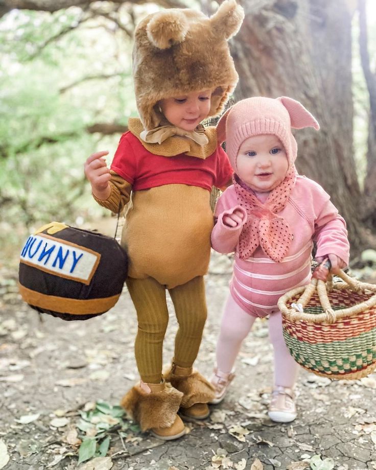 two young children dressed up as winnie the pooh and eebig, one holding a basket