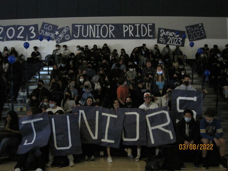 a group of people holding up signs in front of a crowd at a basketball game